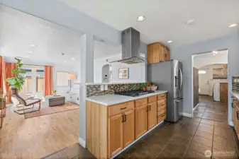Galley Kitchen looking out into Living room space with utility room off other end.