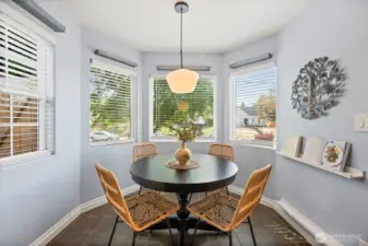 Eating nook off kitchen surrounded by windows bringing in tons of light