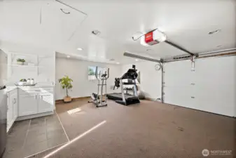 Interior of detached garage space currently setup for home gym with kitchenette and 1/2 bathroom. Possibilities for this space are endless! Open up for 2-car garage, or even convert to a DADU.