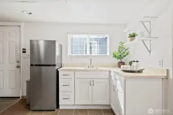 Kitchenette in detached garage brightened by natural light. Perfect spot for refreshments after a workout.
