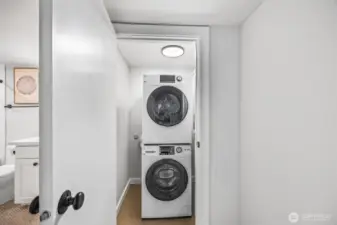 Stackable washer/dryer on lower floor off media/recreation living room.