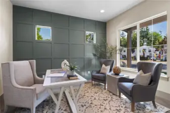 Large office with French door entry, box pattern millwork accent wall, and lovely view out to the evergreens in the distance.