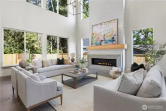 Unique and elevated family room with two-story volume and loads of light. Cast concrete linear fireplace surround, floor-to-ceiling shiplap, and capped with a chunky oak mantle.