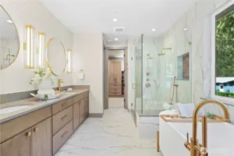 Divine shower wrapped in large-format floor-to-ceiling porcelain tile which lines one side of the bathroom, two shower heads, recessed shampoo niche. Enjoy a bubble bath escape in the modern, oval freestanding soaking tub elevated on sleek gold pedestal legs. Statement tub-filler with shower wand and cozy heated floors.