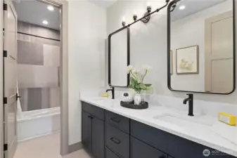 Hall bathroom serves the two-large adjacent bedrooms. Double vanity with slab quartz countertops, under-counter sink, and fun shower room with tub and inset shampoo niche.