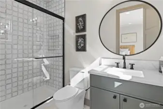 Upper level ensuite bathroom, single vanity sink, large step-in shower with recessed shampoo niche.