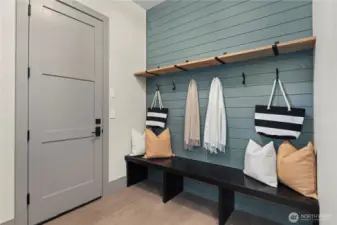 Functional mud room ready to drop bags, kick off shoes, and hang up coats. Utilize hooks on the shiplap wall or in the adjoining coat closet.