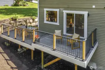 Expansive new Trex deck with custom modern railing overlooks a large backyard.