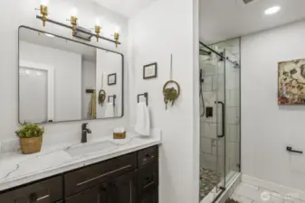 Gorgeous, fully remodeled primary bathroom featuring quartz countertops, designer tile, and a stunning walk-in shower with full tile surround.
