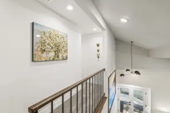 An open hallway leads to two additional bedrooms, each thoughtfully updated with fresh paint, lush carpeting, and stylish finishes.