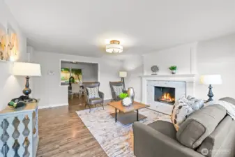 Inside, the living room greets you with natural light and a striking fireplace as the focal point. This space is perfect for gathering and relaxation.