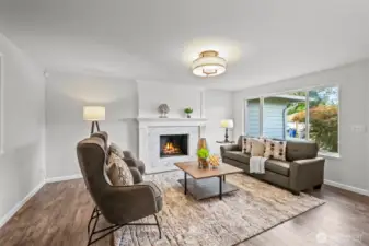 The living area offers an open flow with large windows that frame the front yard, filling the room with light and offering a welcoming atmosphere.