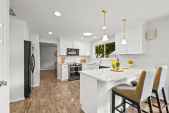 A breakfast bar offers casual seating and connects the kitchen with an additional dining area. This space is ideal for enjoying morning coffee or quick meals.