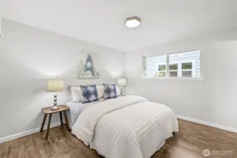 The primary bedroom offers a peaceful retreat with hardwood floors and a large window that brings in abundant natural light.