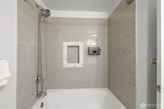 A closer look at the full bath reveals the tiled tub and shower combination, complete with a recessed niche for convenience.