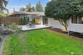 The backyard combines open lawn, landscaping, and hardscape elements, creating an easy-care retreat for relaxation.