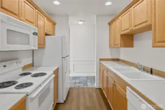 Looking back at the entry way past sparkling white appliances.