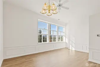 Dining area looking back towards high living room windows, Notice wainscoting panels throughout.