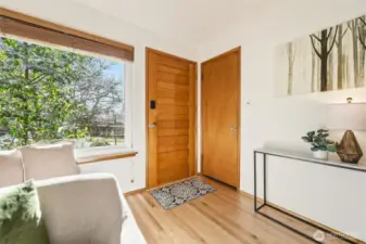 Solid wood, stained front door was installed in 2020.  Coat closet is on the right.  Yes, that is a big front window! All windows throughout the house are Milgard double pane vinyl (iinstalled in 2024)