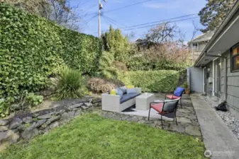 The private backyard is flat with tiered landscaped beds on the north and east sides.