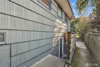 Entrance to the basement is on the west side of the house.  The wooden fence was added during ownership.