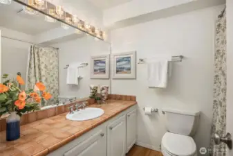 A full bath serves the 2 guest rooms and doubles as a powder room.