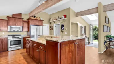 Bright and open kitchen with granite countertop, cherry wood cabinets and stainless appliances.