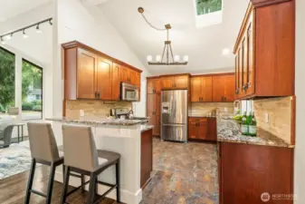 Custom cabinets highlight this remodeled chef's kitchen. Don't miss the vaulted ceilings, skylight, and chandelier lighting.