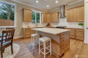Large kitchen area with custom designed karamel stain wood cabinets plus island and stainless finish appliances make this area a chef's dream