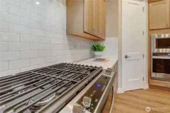 The easy clean/digital Whirlpool range with gas cooktop surrounded by a classic tile backsplash make cooking and clean-up easy.