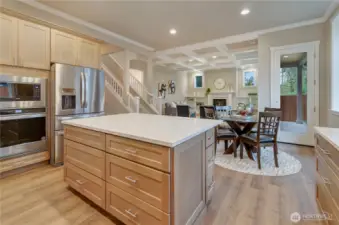 A kitchen island like none other with generous, easy access drawers and a solid quartz surface compliment the adjacent Whirlpool brand double ovens and refrigeration all included in this classic new home.