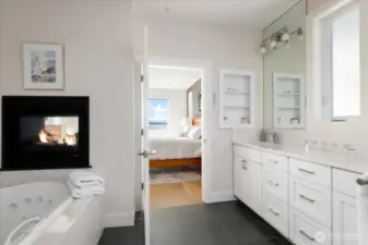 This exquisite 5-piece primary bath offers a spa-inspired retreat with double sinks, sleek quartz countertops, a relaxing soaking tub, and a separate glass-enclosed shower. Directly adjacent, a custom walk-in closet with thoughtfully designed built-ins provides ample storage and organization, seamlessly combining luxury, function, and style