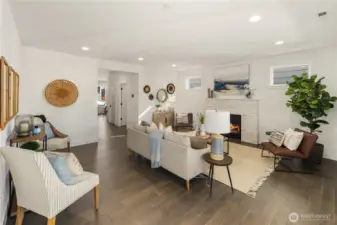 Great Room  This main living area offers a seamless layout designed for connection and comfort. Wide plank flooring runs throughout, while recessed lighting and expansive sightlines create an open, cohesive feel. A modern fireplace with textured surround anchors the room, adding warmth and architectural interest against clean, contemporary lines.    Situated in Bothell near Canyon Park amenities, this integrated living space reflects the elevated design standards associated with high-end contemporary homes. The connected flow supports both everyday living and effortless entertaining within a thoughtfully built residence served by the Northshore School District.    These photos are from a past Robinson Plan at a different community, so overall plan, colors, building orientation, finishes, home outlook, and other details can and WILL vary. All photos, renderings, site maps, and floorplans are for visualization purposes only.