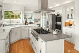 The bright, modern kitchen features six-burner gas cooking and a double oven.
