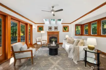Family room features skylights and an elegant fireplace and open effortlessly onto outdoor deck for al fresco living