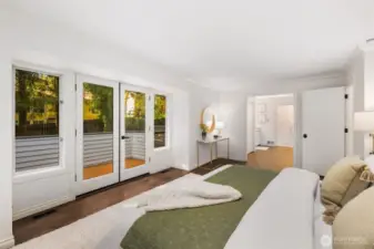 The expansive primary suite also features French doors out to the wrap around deck outside