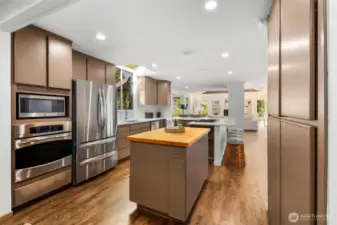 Elegantly refreshed, this chef’s kitchen showcases gleaming quartz countertops, premium stainless steel appliances, and a corner island with seating for up to eight—designed for both lavish entertaining and everyday living.