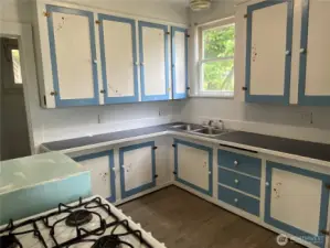 Kitchen is cute and spacious with a vintage feel.