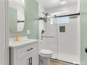 Fresh downstairs bath with step in shower and towel cupboard.