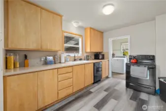 Bright kitchen featuring functional layout, durable laminate flooring, and fresh paint.