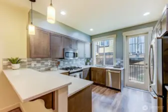 Kitchen area with eating bar, stainless appliance gas stove