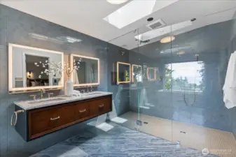 The spa-inspired primary bath is a serene retreat, showcasing Robern Uplift medicine cabinets with sleek vertical lift doors, integrated lighting, and built-in outlets—pairing modern design with everyday convenience.