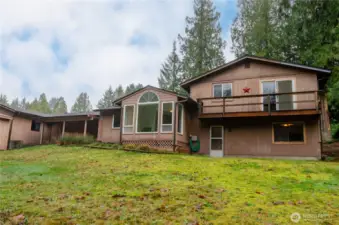 The rear exterior of the home slopes gently to the Salmonberry Creek.