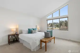 Primary bedroom with vaulted ceiling capturing tons of natural light from the lake.