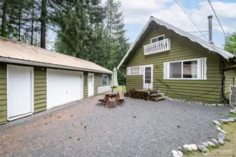 View of the front courtyard featuring a picnic table, string lights, and easy access to both the house, garage, and bonus rec room.