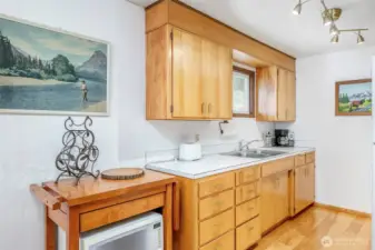 The kitchen features solid wood cabinetry, ample countertop and storage space, and updated lighting—bright, functional, and full of vintage charm.