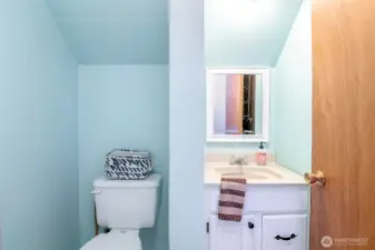 Half bathroom with built-in vanity, and pebble rock floors.