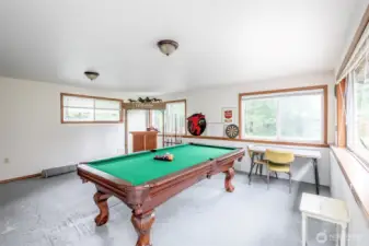 Bonus flex space attached to the garage is currently set up as a game room, complete with pool table, dart board, and bar—perfect for entertaining or converting to a hobby space, studio, or bunk room.
