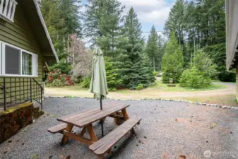 Gravel, open-air courtyard between house and garage, with a picnic table and easy access to both structures. A great spot to unwind after a day on the trails or slopes.