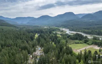 Aerial view of surrounding mountains, river, and neighborhood.